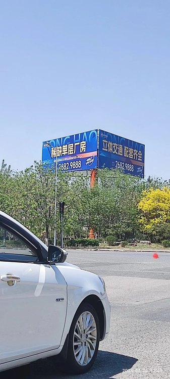 天津北辰三面广告塔侧面视角，可见两个牌面交接