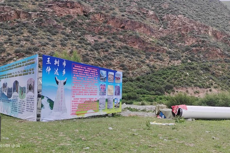 三面广告塔牌体地面组拼，板面画着玉树市仲达乡介绍