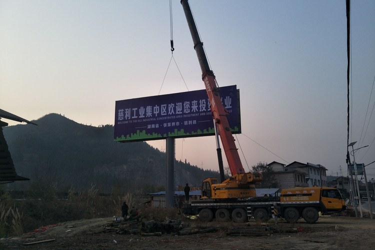 汽车吊把双面广告塔牌体整体吊装到柱顶